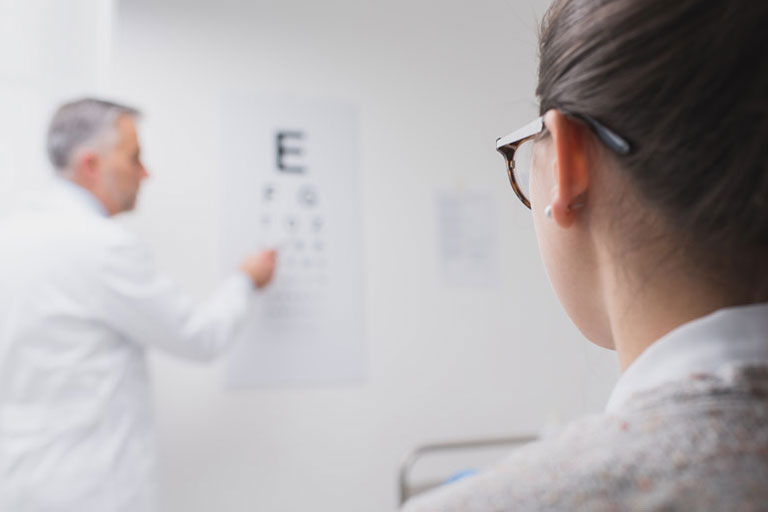 woman taking eye exam using chart